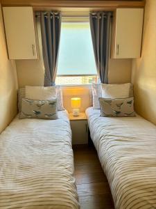 zwei Betten in einem kleinen Zimmer mit Fenster in der Unterkunft Number 51 in Arbroath