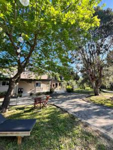 a park with a bench and trees in front of a house at Villa Depiros Corfu in Anapládes