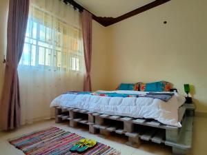 un dormitorio con una cama y una ventana en Lukas' Place, en Kampala