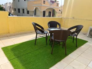 four chairs and a table on a patch of grass at THEE Confort rooms in Pondicherry