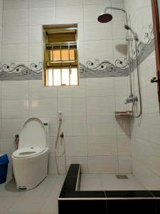 Un baño con inodoro, ventana y ducha. en Lukas' Place, en Kampala 15 fotos más
