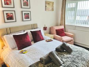 a bedroom with a large bed and a chair at Lovely 4-Bed home sleeps 8 Nr Bolton Stadium & M61 in Blackrod