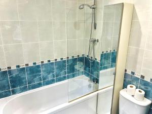 a bathroom with a shower and a tub and a toilet at Lovely 4-Bed home sleeps 8 Nr Bolton Stadium & M61 in Blackrod +51 photos