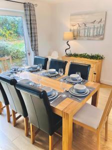 a dining room with a wooden table and chairs at Lovely 4-Bed home sleeps 8 Nr Bolton Stadium & M61 in Blackrod