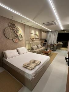 ein Schlafzimmer mit Bett und ein Wohnzimmer in der Unterkunft Flat Amura Carneiros in Praia dos Carneiros