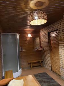 a room with a table and a bench and a light at House By The Sea With Hot Tub in Rīga +20 photos