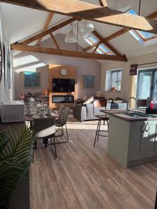 ein Wohnzimmer mit einer Küche und ein Wohnzimmer mit einem Tisch in der Unterkunft Trendy Barn Conversion Families & Groups Sleeps 8 in Midsomer Norton