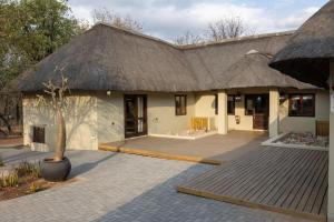 a house with a thatched roof and a courtyard at Landrift Villa in Phalaborwa