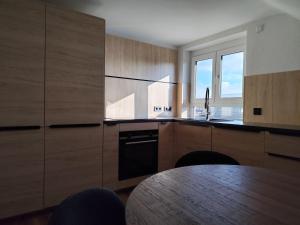 a kitchen with wooden cabinets and a table in it at FeWo Relaxfit in Bad Buchau +11 photos