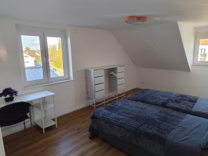 une chambre avec un lit, un bureau et une fenêtre dans l'établissement FeWo Relaxfit, à Bad Buchau