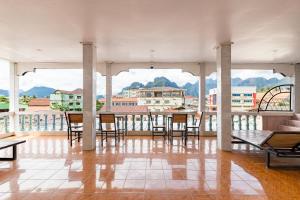 a room with chairs and a table on a balcony at VangVieng Charming Boutique Hotel in Vang Vieng