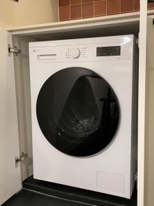 a white washing machine sitting in a kitchen at stay early mansion 가산, 홍대, 고척돔 in Seoul