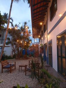 eine Terrasse mit Bänken und Palmen neben einem Gebäude in der Unterkunft Pousada in Bombinhas
