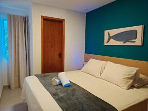 um quarto com uma cama com uma foto de baleia na parede em Condomínio com Piscina a 900 m da praia, Imbassaí Top Flats - ITFs em Imbassaí mais 18 fotografias