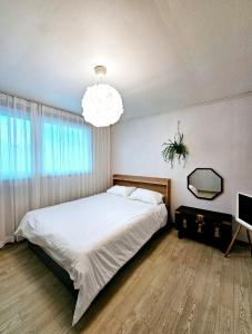 a bedroom with a large bed and a chandelier at 숲애스테이 in Hagwanggyo-dong