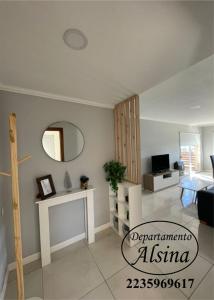 ein Wohnzimmer mit einem Tisch und einem Spiegel in der Unterkunft Alsina Departmento in Necochea
