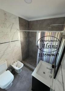ein Badezimmer mit einer weißen Toilette und einem Waschbecken in der Unterkunft Alsina Departmento in Necochea