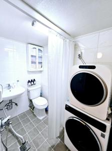 a bathroom with a toilet a sink and a microwave at 숲애스테이 in Hagwanggyo-dong