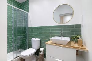 a bathroom with green tiles and a sink and a mirror at Central Studio – Flor De Sol in Tavira +13 photos