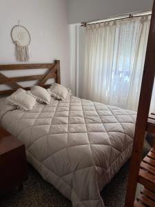 a bedroom with a large white bed with a window at Departamento céntrico en San Bernardo in San Bernardo
