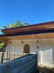 ein Haus mit einem Holzdach und einer Ziegelmauer in der Unterkunft Malinka House in Alegria