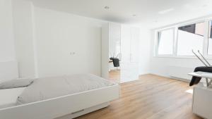 a white bedroom with a bed and a window at Gemütliches Zimmer im Herzen der Stadt in Neuwied