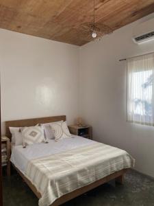 ein Schlafzimmer mit einem Bett mit Holzdecke in der Unterkunft Malinka House in Alegria