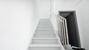 a stairway with white stairs and a black door at Gemütliches Zimmer im Herzen der Stadt in Neuwied +5 photos