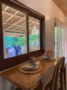 ein Esstisch mit Stühlen und ein großes Fenster in der Unterkunft Malinka House in Alegria + 7 Fotos