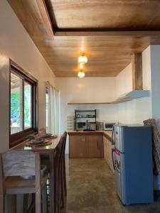 a kitchen with a refrigerator and a table in it at Malinka House in Alegria
