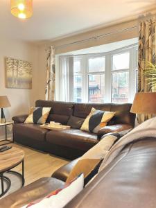 un salon avec un canapé en cuir noir dans l'établissement Ideal 4-bed home sleeps 7 - Nr Trafford Ctr & M60, à Irlam
