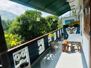 ein Balkon mit einem Gemälde an der Seite eines Hauses in der Unterkunft Ella Hide Forest Cottage in Ella