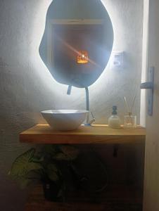 a bowl on a table with a mirror on it at Vila Mar Lofts in Barra Velha