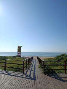 a boardwalk leading to the beach with a lifeguard tower at Vila Mar Lofts in Barra Velha