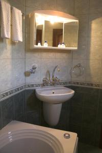 a bathroom with a sink and a toilet and a mirror at Hotel Old Times in Asenovgrad