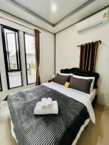 a bedroom with a large bed with two towels on it at Cozy Hideaway 2 BR in Ban Ta Khun