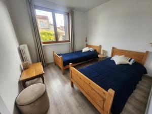a bedroom with two beds and a chair and a window at Appartement Chaleureux, Jardin Privé, Centre ville in Crecy la Chapelle