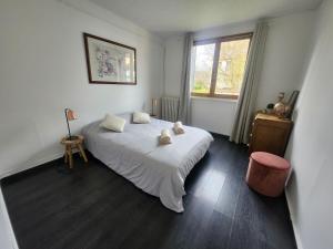 a bedroom with a white bed and a window at Appartement Chaleureux, Jardin Privé, Centre ville in Crecy la Chapelle