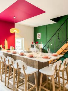 a dining room with a bar with chairs and red and green walls at Le Mexico Duplex Agréable in Lespignan