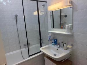 a white bathroom with a sink and a shower at Léman Chic in Geneva