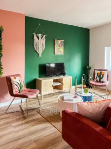 a living room with a couch and a tv at Le Mexico Duplex Agréable in Lespignan