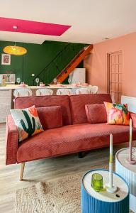 a living room with a red couch and a kitchen at Le Mexico Duplex Agréable in Lespignan