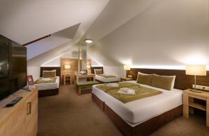 a hotel room with a large bed and a desk at Hotel Honti Wellness és Konferencia Szálloda in Visegrád