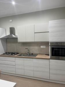 a kitchen with white cabinets and a sink at Nancy's Home in Naples