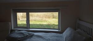 une chambre avec une fenêtre avec un lit devant dans l'établissement Crillaun Cottage, à Foxford 3 autres photos