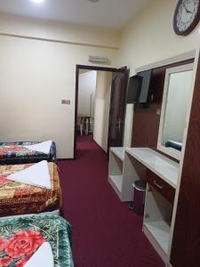 Zimmer mit 2 Betten, einem Schreibtisch und einem Spiegel in der Unterkunft Quality Hotel Apartments in Sabkhah