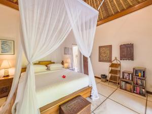 a bedroom with a bed with a mosquito net at Arjuna Villa 3 Bedroom Villa Seminyak in Seminyak +15 photos