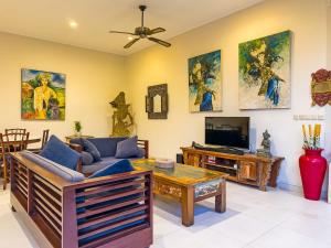 a living room with a couch and a tv at Arjuna Villa 3 Bedroom Villa Seminyak in Seminyak