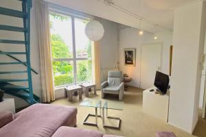 un salon avec un canapé et une chaise dans l'établissement Hello Zeeland - Noordstraat 13-01, à Domburg