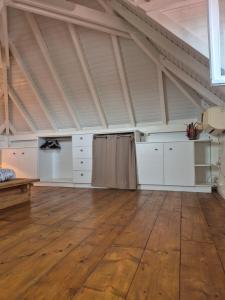 a large room with white cabinets and a wooden floor at Villa malaurelia in Saint-François